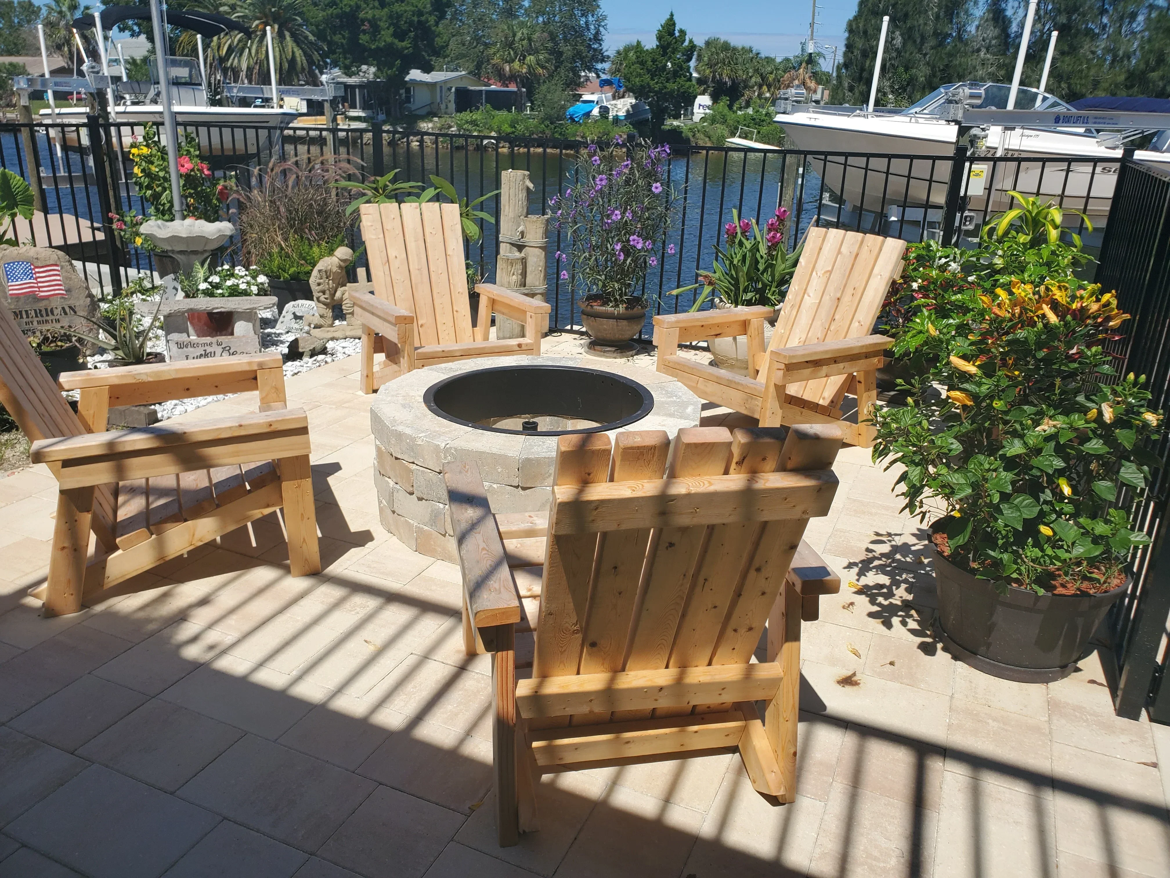 Wooden lounge chairs with slatted construction and central fire pit, natural wood finish