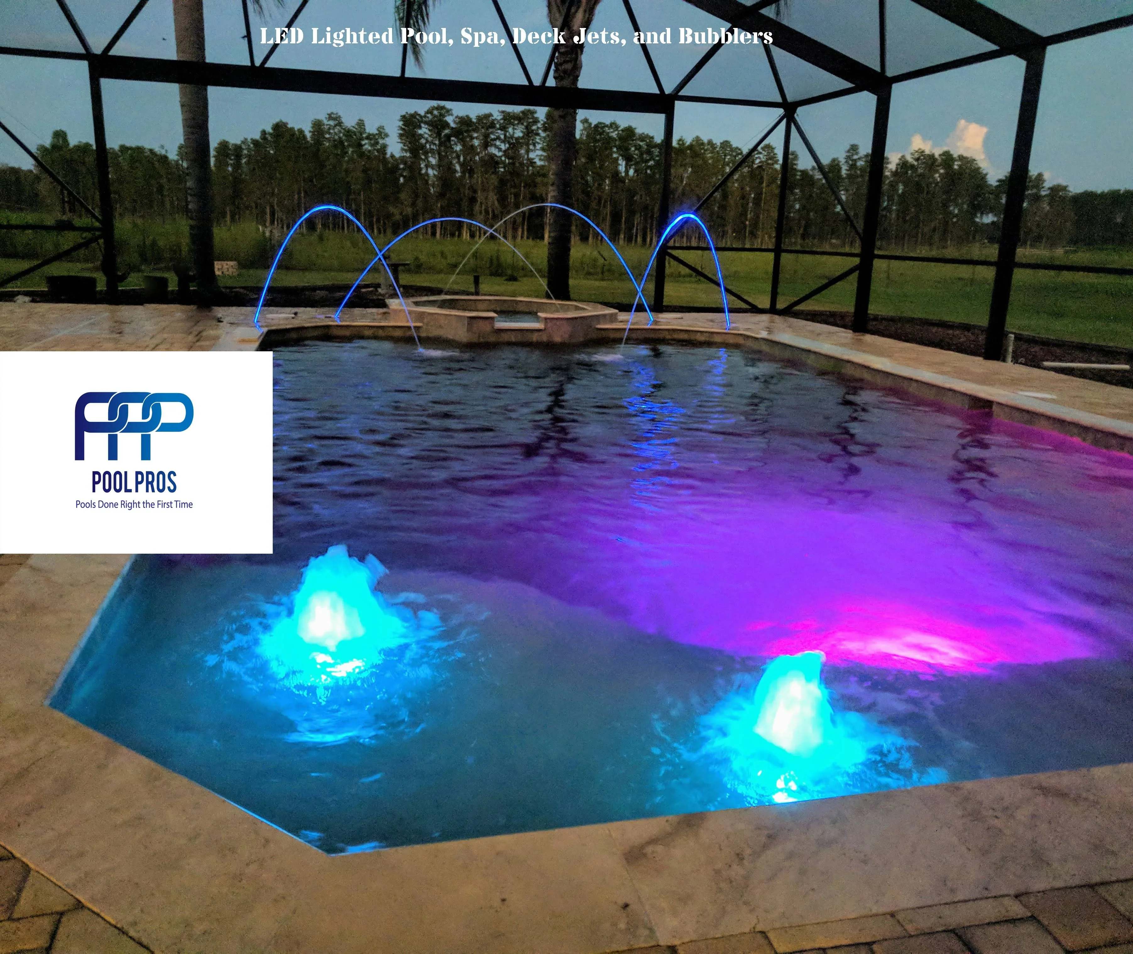 In-ground pool with blue and magenta LED lighting, deck jets, and bubble features under screen enclosure